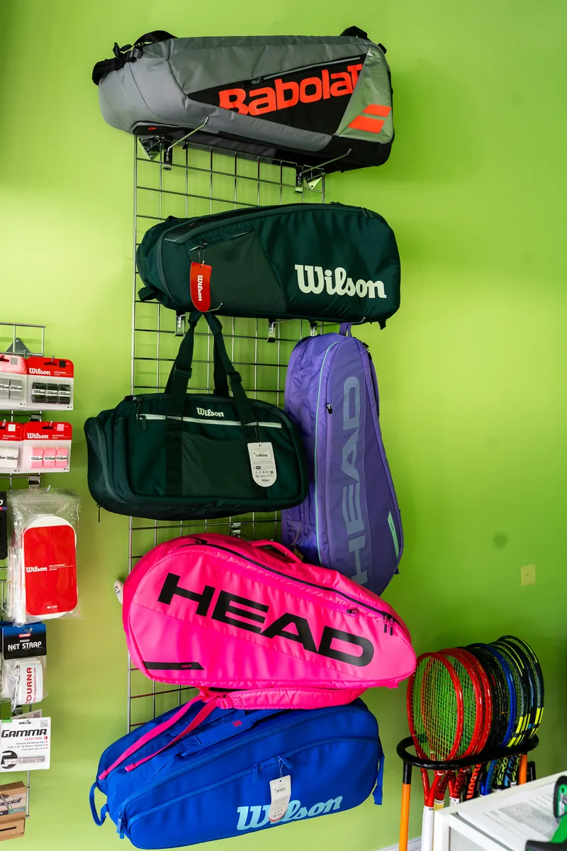 Babolat, Wilson and Head racquet bags hanging at URacquet Shop