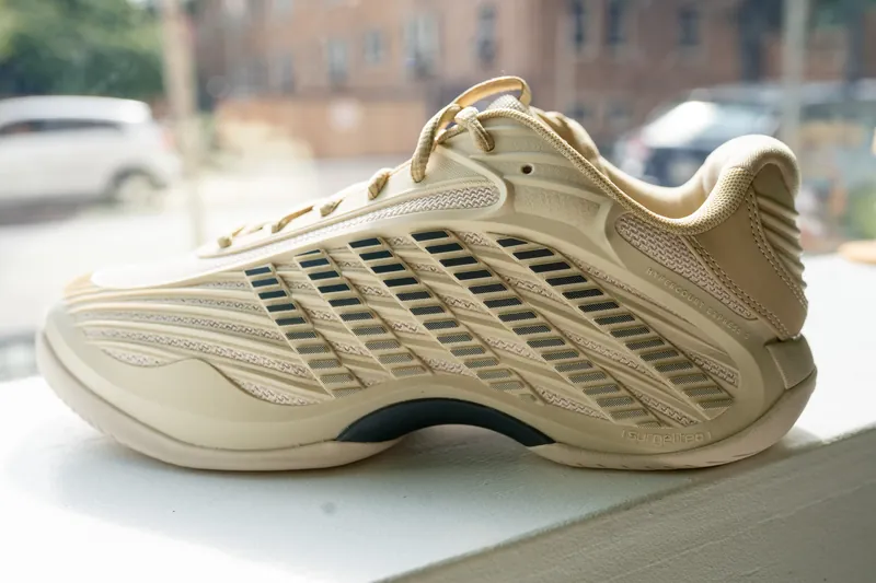 A K-Swiss tennis shoe on the shelf by the window at URacquet Shop