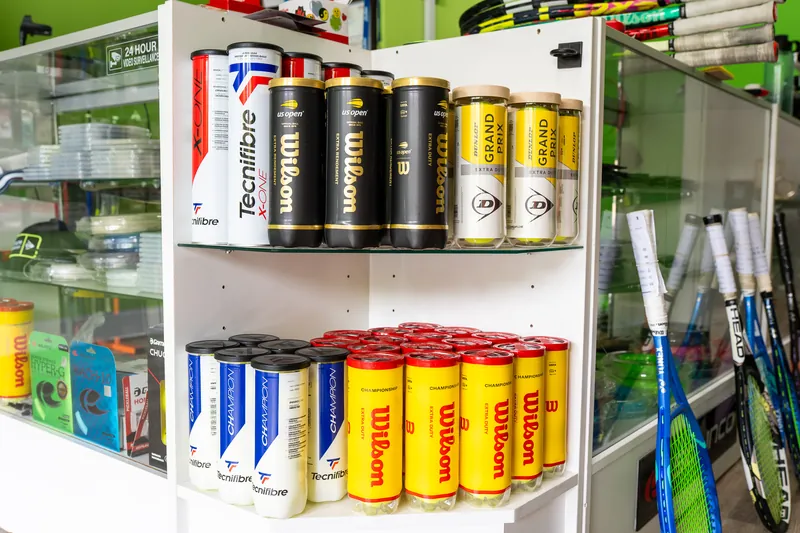 Cans of Tecnifibre, Wilson and Dunlop tennis balls on the shelf at URacquet Shop