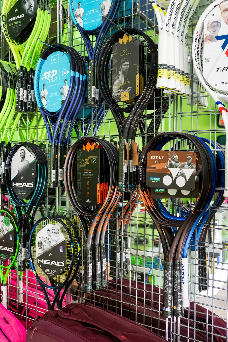 Head, Yonex and Wilson racquets hanging on the racquet wall at URacquet Shop