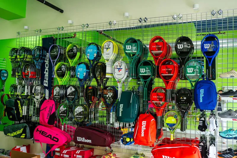 The racquet wall at URacquet Shop: Babolat, Wilson and Head racquets and bags